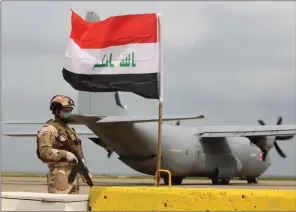  ??  ?? An Iraqi soldier stands guard in front US military air carrier at the Qayyarah air base as US troops pull out on Thursday. (AFP)