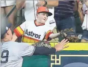  ?? Tony Gutierrez / The Associated Press ?? A young fan catches a home run hit by Houston’s Carlos Correa in front of New York’s Aaron Judge during the fourth inning of Saturday’s ALCS game.