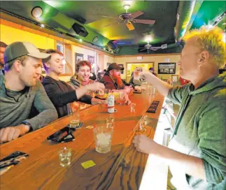  ?? William Glasheen The Associated Press ?? Owner Michael Mattson toasts the opening of the Friends and Neighbors bar in Appleton, Wis., following the Wisconsin Supreme Court’s decision to strike down Gov. Tony Evers’ restrictio­ns.