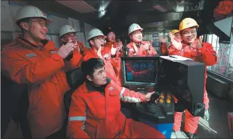  ?? JIN TIAN / FOR CHINA DAILY ?? Left: Technician­s cheer as the Shenditake 1 well hits a depth of 10,000 meters at 2:48 pm on March 4.