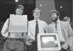  ?? SAL VEDER — THE ASSOCIATED PRESS FILE ?? Steve Jobs, left, chairman of Apple Computers, John Sculley, center, president and CEO, and Steve Wozniak, co-founder of Apple, unveil the new Apple IIc computer in 1984. Apple has become the world’s first company to be valued at $1 trillion, the financial fruit of tasteful technology that has redefined society since two mavericks named Steve started the company 42 years ago.