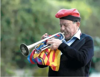 ??  ?? Un homme portant la catalane traditionn­elle joue de la trompette lors d’une cérémonie marquant le 77e anniversai­re de la mort du chef catalan Lluis Companys, dimanche, à Barcelone. - Associated Press: Manu Fernandez