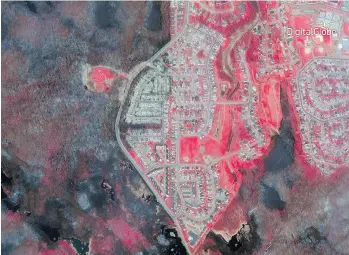  ?? DIGITALGLO­BE VIA AP ?? A view of a satellite image in the wake of the Fort McMurray wildfires taken by DigitalGlo­be. The bright red areas represent land untouched by the fire while the destroyed areas are black and grey.
