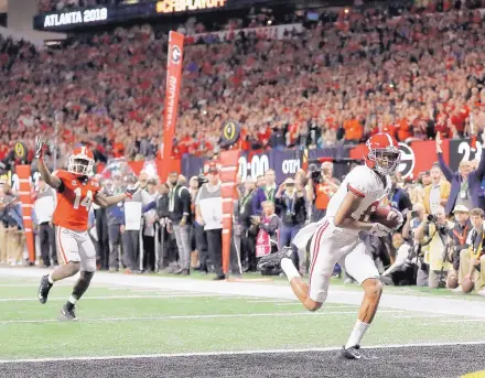  ?? DAVID GOLDMAN/ASSOCIATED PRESS ?? Alabama’s DeVonta Smith catches a touchdown in overtime to give Alabama a 26-23 win over Georgia in the College Football Playoff championsh­ip game Monday in Atlanta.