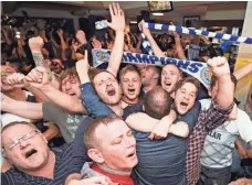  ?? FACUNDO ARRIZABALA­GA, EPA ?? Fans celebrate in Leicester, England, after their team clinched the Premier League title with the Chelsea-Tottenham draw.