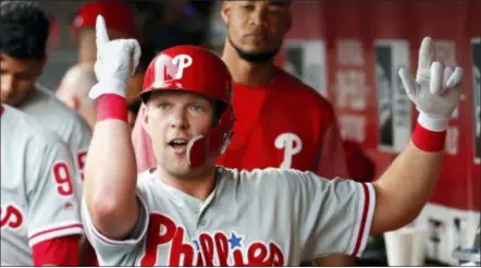  ?? JOHN MINCHILLO — THE ASSOCIATED PRESS ?? The Phillies’ Rhys Hoskins celebrates in the dugout after hitting a solo home run off Cincinnati starting pitcher Tyler Mahle during the first inning Thursday in Cincinnati. Hoskins hit another home run in the sixth as the Phillies won, 9-4.