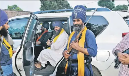  ?? RAVI KUMAR/HT ?? Flanked by private guards, Budha Dal head Balbir Singh in his bullet-proof car; (right) a cop with light machine gun in his cavalcade in Hoshiarpur on Wednesday.