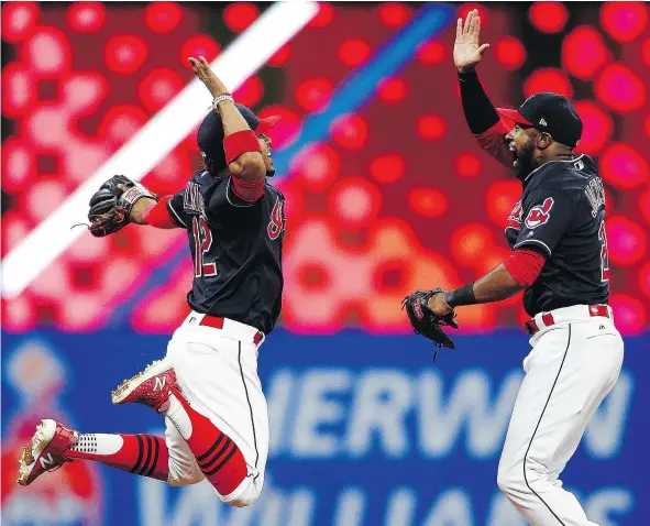  ?? — THE ASSOCIATED PRESS ?? Cleveland Indians Francisco Lindor, left, and Austin Jackson celebrate a 2-0 victory over the Detroit Tigers on Tuesday in Cleveland. The Indians extended their winning streak to 20 games and are one win away from the Cubs’ 21-win MLB standard.