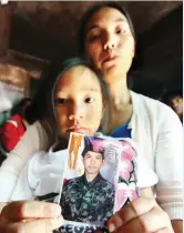  ??  ?? TRAGIC TURN OF EVENTS – Robely Tegwa and her four-year-old daughter Kiesh Darriel hold a photo of PO3 Daniel Tegwa, one of the latest heroes of Marawi, who was killed by a sniper’s bullet just moments after he called up his family that his team had...