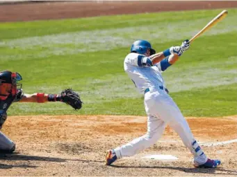  ?? THE ASSOCIATED PRESS ?? The Los Angeles Dodgers’ Cody Bellinger, right, hits a solo home run with Atlanta Braves catcher Tyler Flowers watching during the eighth inning Sunday in Los Angeles.