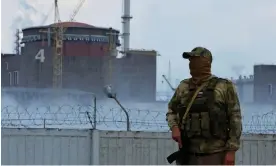 ?? Photograph: Alexander Ermochenko/Reuters ?? A Russian soldier stands guard near Zaporizhzh­ia nuclear plant. The UN has called for an end to all military activity around the site.
