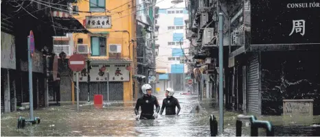  ?? FOTO: AFP ?? Schwierige Rettungsmi­ssion in Macau: Einsatzkrä­fte kämpfen sich am Sonntag nach dem Taifun „Mangkhut“durch die Fluten.