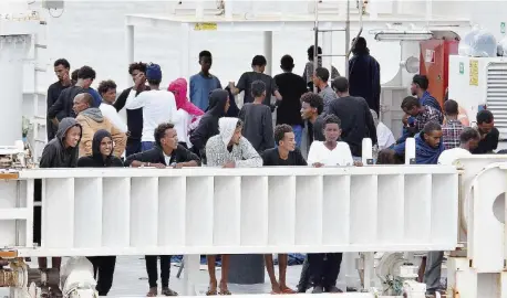  ?? Ansa ?? Prima e dopo lo sbarco Migranti sul pattugliat­ore e, a destra, durante la discesa sul molo di Catania