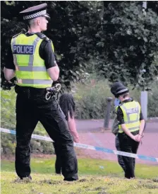  ??  ?? CORDON Officers stand guard close to where bloodshed occurred