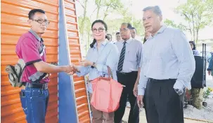  ??  ?? KEMUDAHAN BERSAMA: Ahli Dewan DBKU Datin Mary Sadiah Zainuddin menyerahka­n kunci kepada salah seorang tukang kasut di ’Green Kiosk Esplanade’ pada 1 November lalu. Turut kelihatan Ketua Timbalan Pengarah DBKU Jumaini Haili (tengah) dan Timbalan...