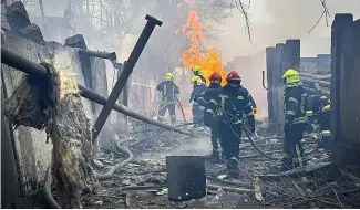  ?? ?? Rescue workers in Ukraine.