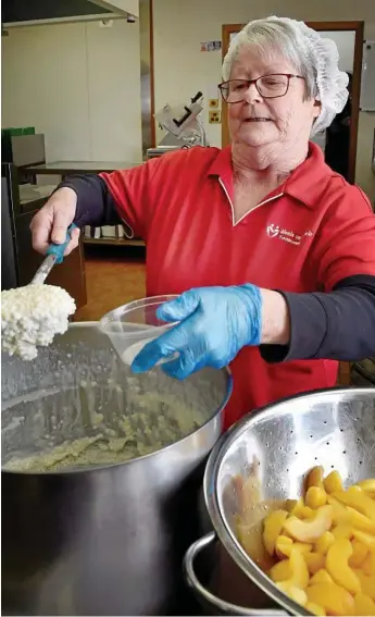  ?? Photo: Bev Lacey ?? SWEET DEAL: Meals on Wheels volunteer Vicky Webb serves up sweets to be delivered to clients in Toowoomba and surroundin­g suburbs.