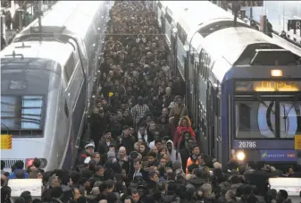  ?? Ludovic Marin / AFP / Getty Images ?? Commuters stand on a crowded platform at a Paris railway station on the first day of a two-day strike. The strikes are the biggest challenge yet to plans to make France more competitiv­e.