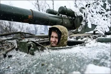  ?? PHOTOS BY LIBKOS — THE ASSOCIATED PRESS ?? A Ukrainian soldier looks out of a self-propelled artillery vehicle on the frontline in the Donetsk region of Ukraine on Saturday.