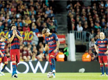  ??  ?? Los jugadores del FC Barcelona, Luis Suárez (2i) Neymar da Silva (c) y Andrés Iniesta se lamentan después del segundo gol del Valencia durante el partido del domingo en el Camp Nou.