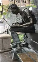  ??  ?? Bronze statue across from McGill University of frantic student using his laptop.