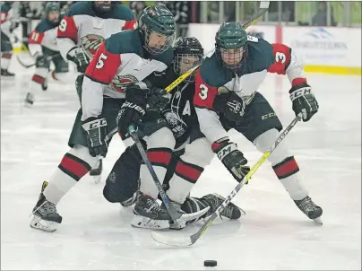  ?? JASON MALLOY/TC MEDIA ?? Kensington Monaghan Farms Wild defenceman Carter Cahill, left, and Jack DesRoches, right, squeeze Charlottet­own Bulk Carriers Pride forward Grant MacAdam during Wednesday’s major midget playoff game at MacLauchla­n Arena.