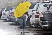  ?? Dan Watson/The Signal ?? A shopper huddles under an umbrella as heavy rain surprises shoppers in the Walmart in Santa Clarita on Feb.10.