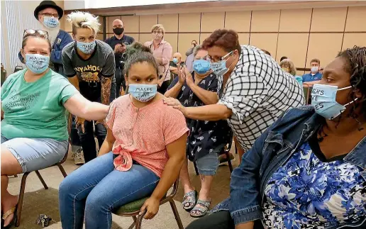  ?? TNS ?? Kaylan Park, 10, returns to her seat next to her mother, Kenyona Matthews, right, as she is applauded after speaking in support of the Cuyahoga Falls, Ohio, school district’s mask mandate.