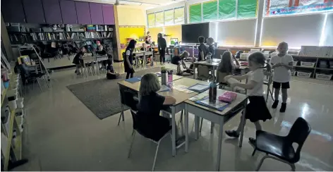  ?? JULIE JOCSAK/POSTMEDIA NEWS ?? Staff at St. Edward Catholic School in Jordan try to keep students as cool as possible during record-breaking heat on Monday. The classroom lights were off, such as in teacher Karen Petrovsky's Grade 2 class above, and students had indoor recess and...