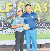  ??  ?? HADIAH KHAS: Roslan menyampaik­an hadiah kepada Amirrufath­ul lah Muizzuddin Amirrulliz­am Hossen, 11 tahun yang menyerta Pertanding­an Golf Klasik Antara Umur 2018 baru-baru ini.