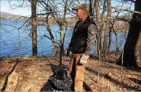  ??  ?? Troy Mayor Patrick Madden helps collect trash from the Tomhannock Reservoir.