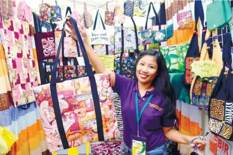  ?? (SUN.STAR FOTO/ARNI ACLAO) ?? LEARNING FROM THE MARKET. Sundry Fashions and Creations CEO Mildred Caceres shows some of their products during the USC Entreprene­urs’ Fair at Ayala Activity Center.