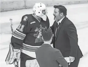  ?? MATT DAYHOFF/JOURNAL STAR ?? Peoria Rivermen head coach Jean-Guy Trudel, right, celebrates with goaltender Nick Latinovich after Game 2 on Saturday.