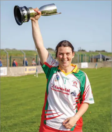  ??  ?? Kiltegan captain Tania Wynne lifts the Intermedia­te cup after their victory over Annacurra in the county final in Pearse’s Park, Arklow.
