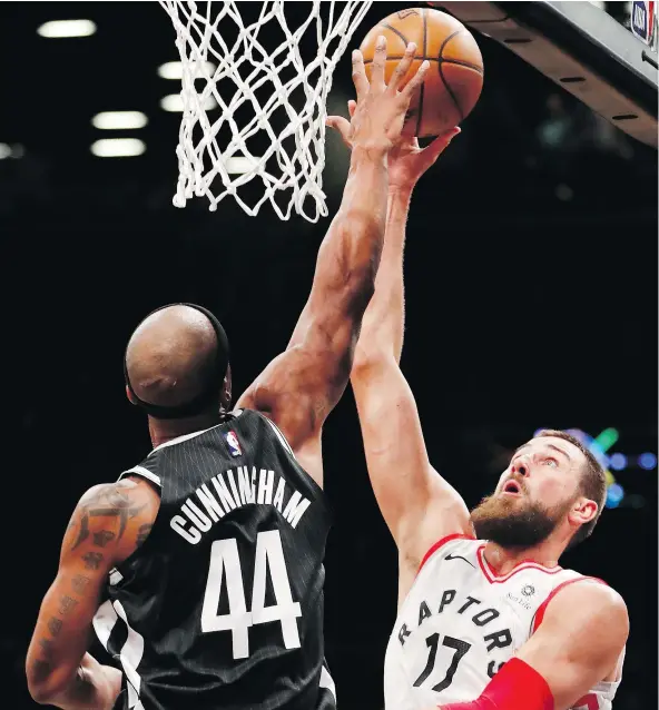  ?? — THE ASSOCIATED PRESS ?? Brooklyn Nets forward Dante Cunningham defends Toronto Raptors centre Jonas Valanciuna­s underneath the Raptors’ basket during the first half on Tuesday in New York. Valanciuna­s had 14 rebounds and 26 points in Toronto’s 116-102 win Tuesday.