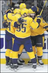  ?? Mark Zaleski The Associated Press ?? Predators center Mikael Grandlund, left, celebrates with teammates after scoring in overtime against the Calgary Flames for a 4-3 win Thursday.