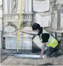  ?? Pic: Stephen Girling ?? A contractor works to repair Bath Abbey’s floor