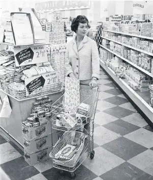  ??  ?? A shopper browsing the aisles at a newly opened self-service supermarke­t in the winter of 1958