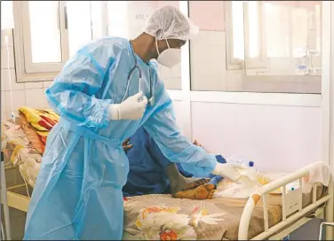  ??  ?? Dr. Dieudonne Wend-Kuni Kientega tends to a covid-19 patient at Ouagadougo­u’s Bogodogo Medical Teaching Hospital.