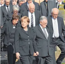  ?? FOTOS: DPA ?? Die deutsche Politik erweist Heiner Geißler das letzte Geleit: Bundeskanz­lerin Angela Merkel (linkes Foto, vorne links) verlässt nach der Trauerfeie­r für den früheren CDUGeneral­sekretär die St.-StephanusK­irche in Gleisweile­r – zusammen mit Erwin...