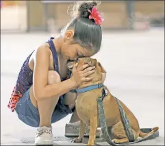  ??  ?? It’s no act: Dogs get pleasure from bonds with humans — like the one between Reniah Knight and Buster, reunited after Hurricane Harvey.