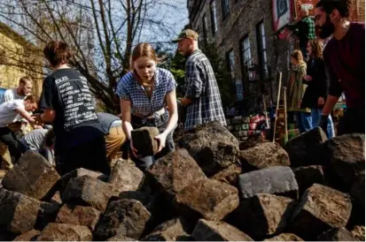 ?? IDA MARIE ODGAARD/RITZAU SCANPIX VIA ASSOCIATED PRESS ?? Citizens of the free village of Christiani­a dug up cobbleston­es on Pusher Street.