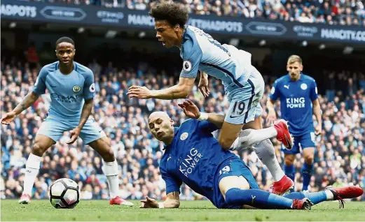  ??  ?? Down and in: Manchester City’s Leroy Sane is brought down inside the box by Leicester’s Yohan Benalouane resulting in a penalty in the English Premier League match at the Etihad on Saturday. Below: Gabriel Jesus converting the spot-kick for the second...