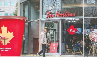  ?? CHINA OUTSTR / AFP / GETTY IMAGES ?? A man walks past a Tim Hortons store in Shanghail last February. The chain has significan­t expansion plans for China.