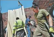  ?? HECTOR RETAMAL / AGENCE FRANCE-PRESSE ?? Workers install a water tank on a building on Lexington Ave on May 9 in New York.