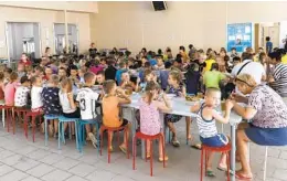  ?? AP FILE ?? Children from different orphanages from Ukraine’s Donetsk region eat a meal at a camp in Zolotaya Kosa, in southweste­rn Russia.