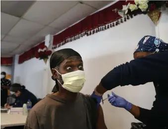  ?? NAncy lAnE / hErAld sTAFF ?? YOU WON’T FEEL A THING: Reginald Jean-Baptiste gets vaccinated by the Whittier Street Health Center at a clinic for Haitian Americans Wednesday in Mattapan.