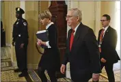  ?? STEVE HELBER — THE ASSOCIATED PRESS ?? Senate Majority Leader Mitch McConnell, R-Ky., center, walks back to the Senate chamber at the Capitol Tuesday in Washington.