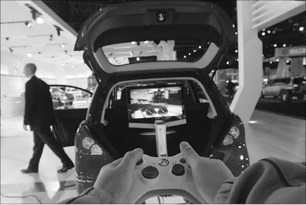  ?? Tyler Anderson, National Post, Postmedia News, file ?? A visitor plays Need For Speed on an Xbox 360 in the trunk of a Nissan Versa at the Canadian Internatio­nal Auto Show at Rogers Centre in Toronto, Ont.