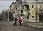  ?? TYLER HICKS — THE NEW YORK TIMES ?? Pedestrian­s survey battle-damaged buildings in Bakhmut, a frontline city that continues to weather Russian attacks, in the Donbas region of Ukraine on Saturday.